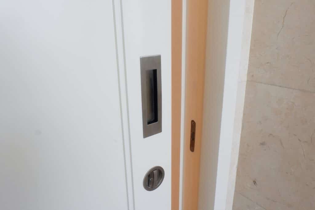 Recessed door handle on white wooden sliding door