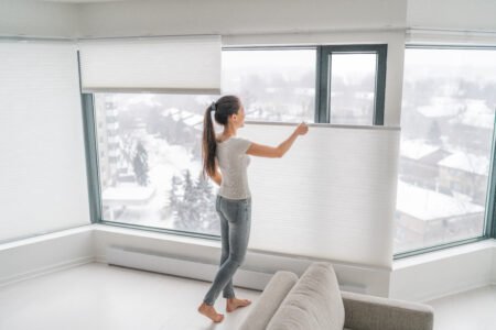 Woman opening home curtains in urban condo