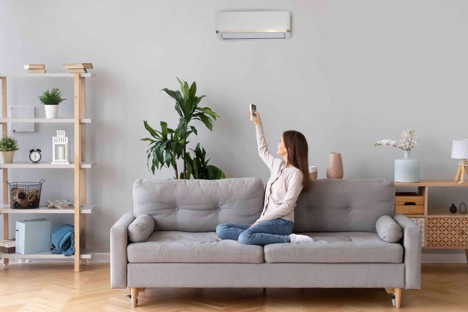 woman switching on air conditioner woman switching on air conditioner