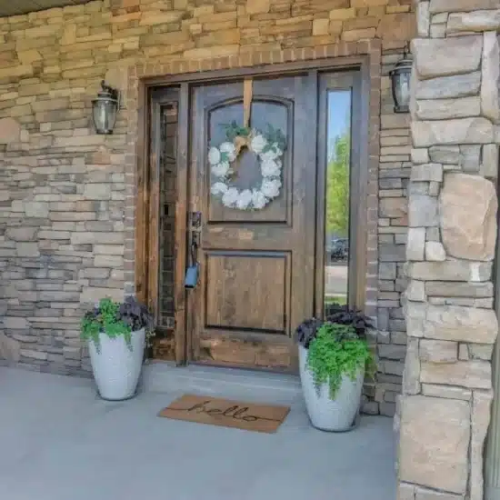 Front door exterior with stone wall 1200x675 1