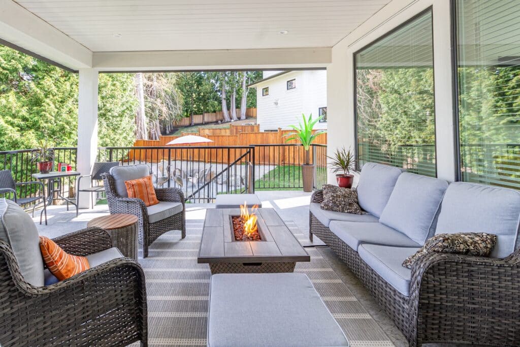 A luxurious spacious deck with stylish patio furniture with a fire pit table heater