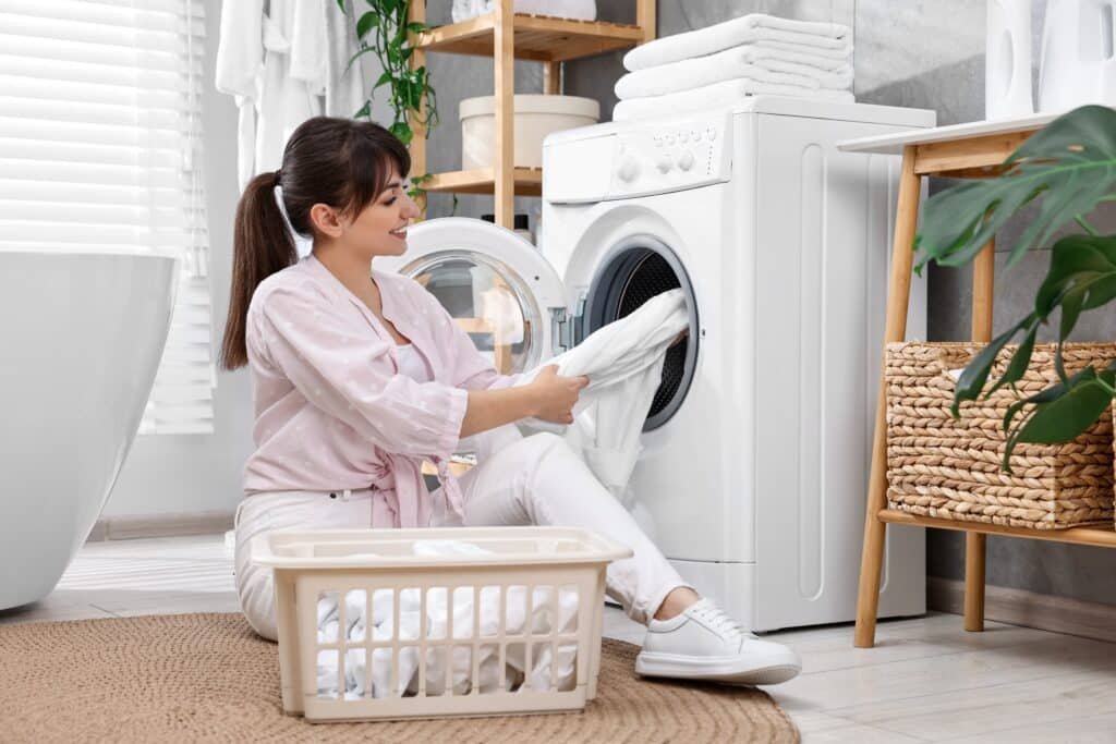 Happy housewife doing laundry Happy housewife doing laundry