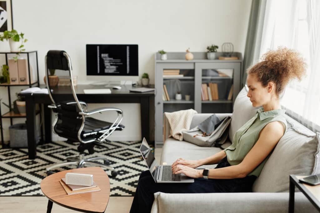 Woman sitting on sofa and working in the living room at home Woman sitting on sofa and working in the living room at home