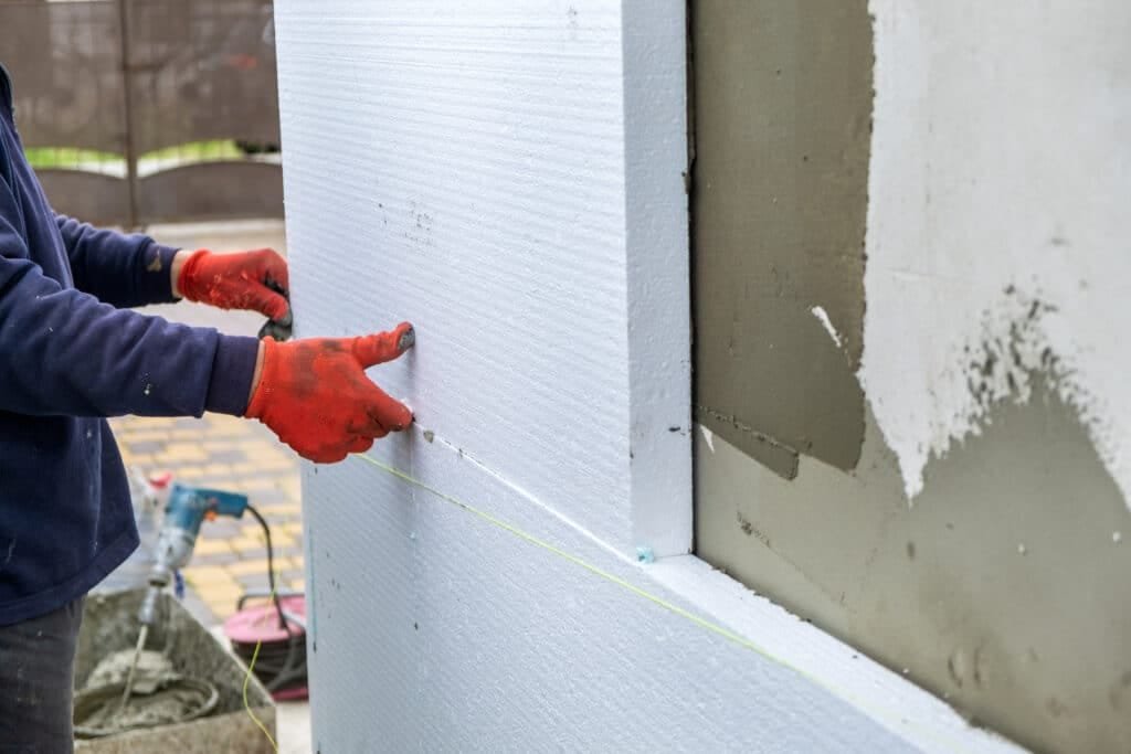 Construction worker installing styrofoam insulation