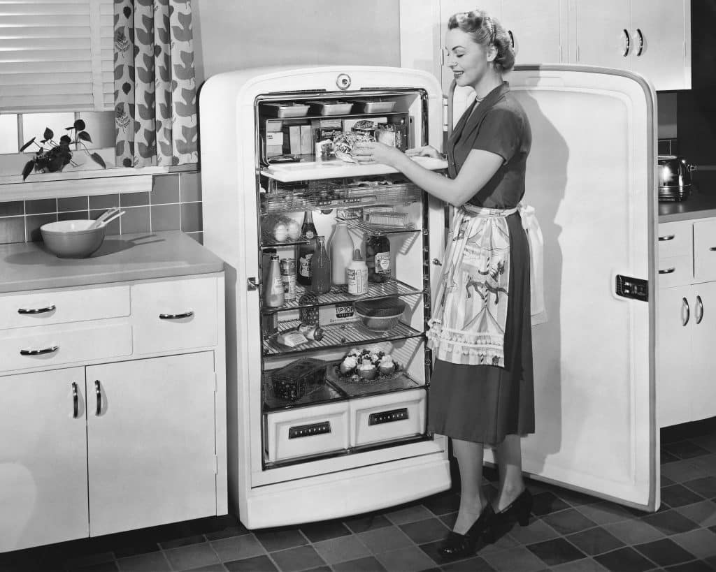 A woman standing in front of a refrigerator