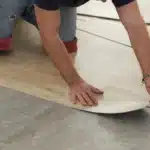 Worker installing new vinyl tile floor