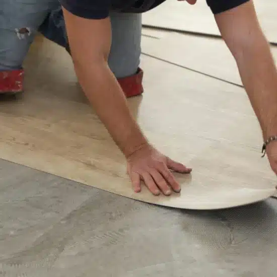 Worker installing new vinyl tile floor